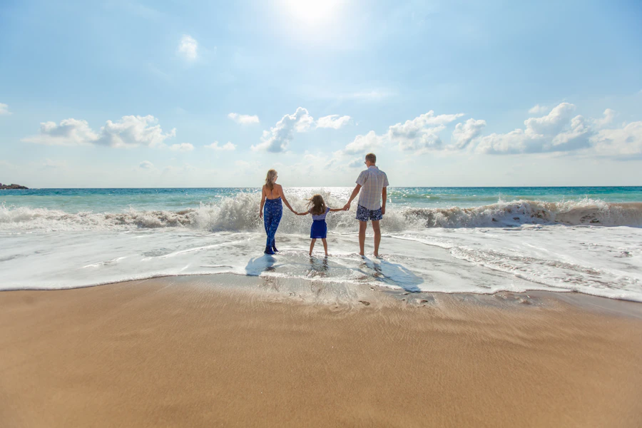 Família de mãos dadas à beira-mar
