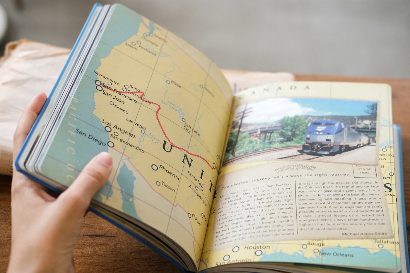 Mãos a folhear um livro de viagens com um percurso marcado no mapa